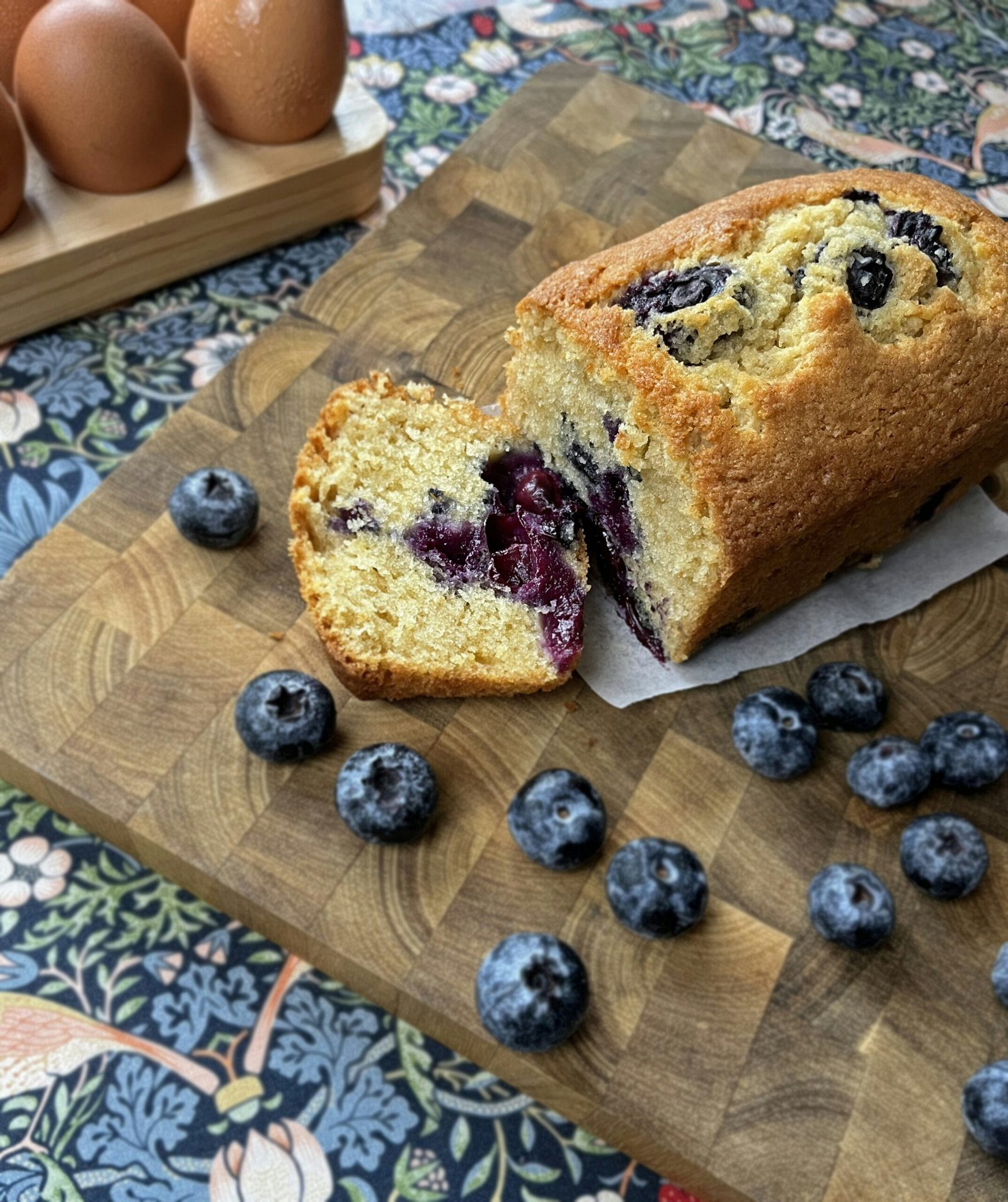 a loaf of blueberry bread sitting on top of a cutting board